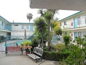Gardena apartment for rent - a patio with benches and a table in front of a building