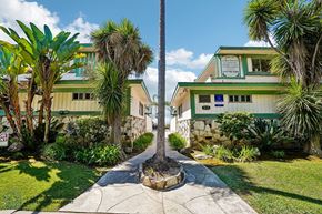 Gardena apartment for rent - A green building with a sign on it and a tree in front.