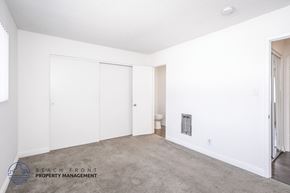 Torrance apartment for rent - A white bedroom with a carpeted floor and a window.