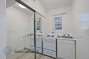 Inglewood apartment for rent - a white kitchen with white appliances and a mirror and a stove top oven and sink