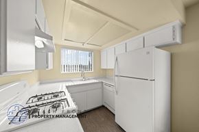 Hawthorne apartment for rent - A white refrigerator in a kitchen with a stove top and a window.