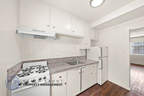 Hawthorne apartment for rent - A kitchen with white cabinets and a stove top oven.