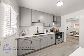 Anaheim apartment for rent - A kitchen with a logo for Beach Front Property Management.