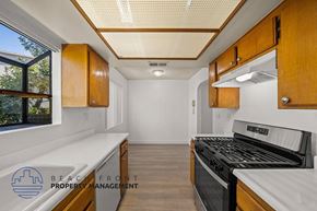 Inglewood townhouse for rent - a kitchen with wooden cabinets and a stove and a window