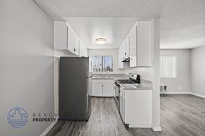 Los Angeles apartment for rent - A kitchen with white cabinets and a refrigerator in a property.