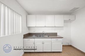 Cudahy apartment for rent - an empty kitchen with white cabinets and a sink
