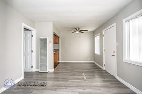 Downey apartment for rent - A spacious room with a ceiling fan and wooden flooring.