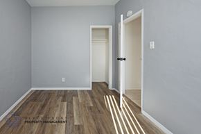 Long Beach apartment for rent - A room with wooden flooring and two white doors.