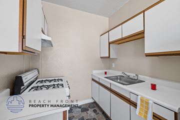 Los Angeles apartment for rent - A kitchen with white cabinets and a stove top oven.