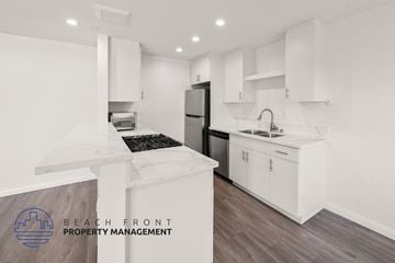 Buena Park apartment for rent - A kitchen with white cabinets and a wooden floor.