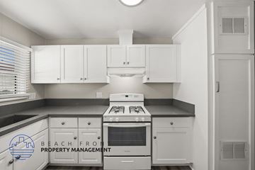 Santa Ana apartment for rent - A kitchen with white cabinets and a stove top oven.