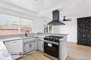 Westminster apartment for rent - A modern kitchen with a stove top oven and a fan hood.