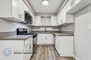 Torrance townhouse for rent - A kitchen with white cabinets and a stove top oven.