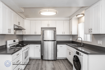 Hawthorne apartment for rent - A kitchen with white cabinets and a stainless steel refrigerator.