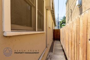 Long Beach apartment for rent - the side of a building with a sidewalk and a wooden fence