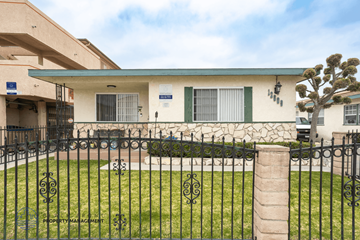 Hawthorne apartment for rent - A building with a green fence in front of it.