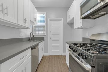 Long Beach apartment for rent - A kitchen with white cabinets and a stainless steel stove.