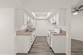 Long Beach apartment for rent - A kitchen with white cabinets and a wooden floor.