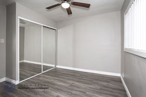 Downey apartment for rent - A room with a ceiling fan and sliding glass doors.