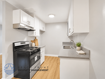 Long Beach apartment for rent - A modern kitchen with a black stove top oven and white cabinets.