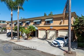 Long Beach apartment for rent - A white car is parked in front of a building with the sign "BEACH FRONT PROPERTY MANAGEMENT".