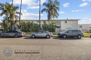 Hawthorne apartment for rent - Three cars are parked in a lot with a building and palm trees in the background.
