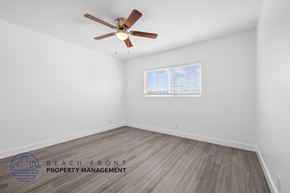 Signal Hill apartment for rent - A room with a ceiling fan and wooden flooring.