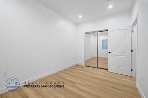 Long Beach apartment for rent - a bedroom with white walls and wood flooring and a white door