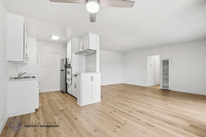 Gardena apartment for rent - A spacious kitchen with white cabinets and a wooden floor.
