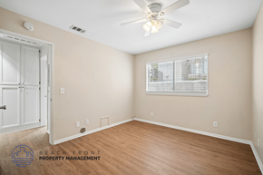 Lakewood apartment for rent - A room with a ceiling fan and a window with blinds.