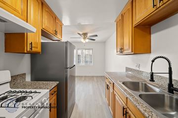 Gardena apartment for rent - A kitchen with wooden cabinets and a black refrigerator.