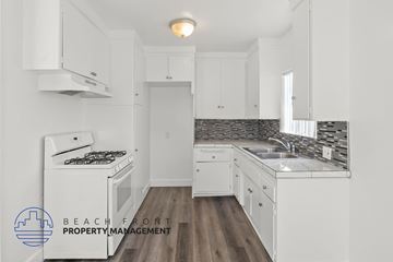 Inglewood apartment for rent - A kitchen with white cabinets and a wooden floor.