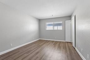 Hawthorne apartment for rent - A room with wooden flooring and a window with blinds.