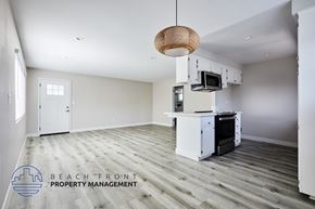 Redondo Beach apartment for rent - A spacious kitchen and living room with a wooden floor and white walls.