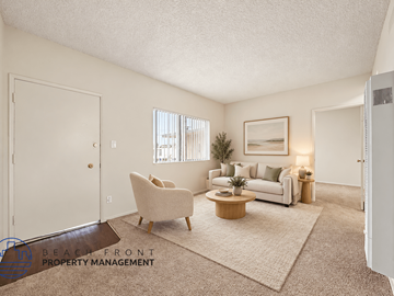Wilmington apartment for rent - A living room with a white couch, a chair, a coffee table, and a painting on the wall.