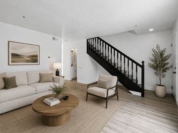 Westminster apartment for rent - A living room with a white couch, a wooden coffee table, a chair, a potted plant, and a painting on the wall.