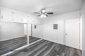 Long Beach apartment for rent - A spacious room with a ceiling fan and wooden flooring.