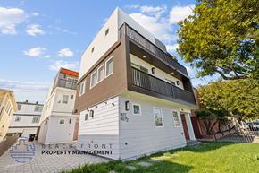 San Pedro townhouse for rent - A modern building with a sign that says "BEACH FRONT PROPERTY MANAGEMENT".