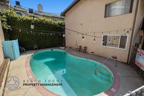 Inglewood apartment for rent - a backyard swimming pool with a building and a chain link fence