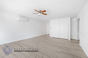 San Pedro apartment for rent - A room with a ceiling fan and a logo for Beach Front Property Management.