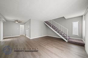 Hawthorne apartment for rent - A spacious room with a staircase leading to another level.