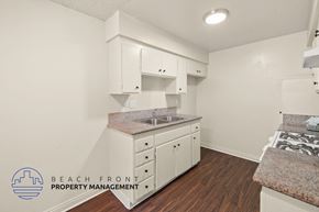 Paramount apartment for rent - A kitchen with white cabinets and a granite countertop.