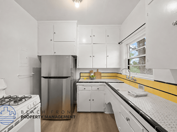 Riverside apartment for rent - A kitchen with white cabinets and a yellow stripe on the wall.