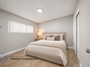 Cudahy apartment for rent - A bedroom with two beds and a nightstand with a lamp.