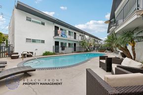 Newport Beach townhouse for rent - A pool area with lounge chairs and a building in the background.