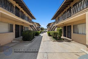 Inglewood apartment for rent - a long walkway between two buildings with balconies and bushes