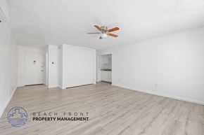 San Pedro apartment for rent - A spacious room with a ceiling fan and wooden flooring.