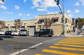 Long Beach apartment for rent - Cars are parked on the street in front of a building with a sign that says "Beach Front Property Management.".