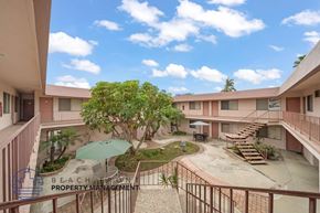 Hawthorne apartment for rent - A courtyard with a tree and a table surrounded by buildings.