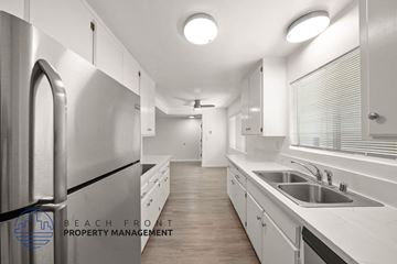 Santa Monica apartment for rent - A modern kitchen with white cabinets and stainless steel appliances.